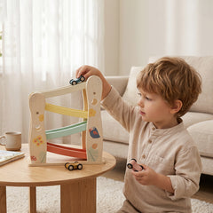 Toddler playing with wooden car ramp toy by Guanyi Toys